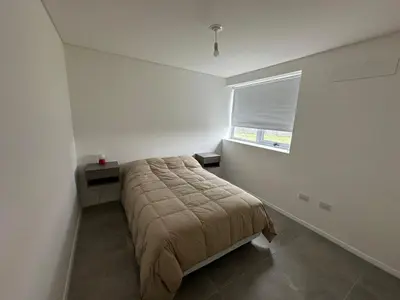 a bedroom with a bed and a window at Departamento Complejo Ciudad Gama in Cordoba
