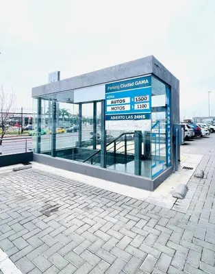 a building with a sign in a parking lot at Departamento Complejo Ciudad Gama in Cordoba