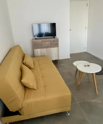 a living room with a couch and a table at Departamento Complejo Ciudad Gama in Cordoba