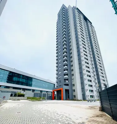 a tall white building next to a large building at Departamento Complejo Ciudad Gama in Cordoba