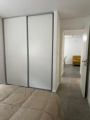 a bedroom with sliding glass doors and a bed at Departamento Complejo Ciudad Gama in Cordoba