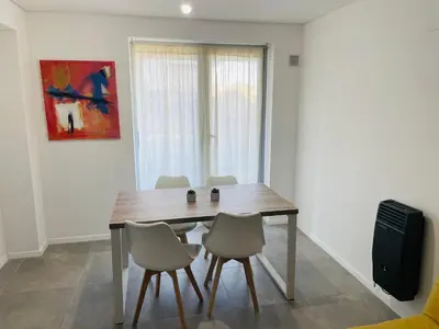 a dining room with a wooden table and chairs at Departamento Complejo Ciudad Gama in Cordoba