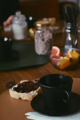 a cup of coffee sitting on a table with a sandwich at Hostel céntrico Casa Revol in Cordoba