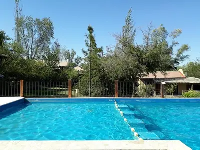 a swimming pool with blue water in a yard at Cabañas Pedras Moras in Tanti