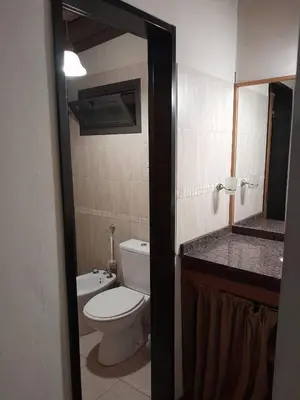 a bathroom with a toilet and a sink and a mirror at Cabañas Pedras Moras in Tanti