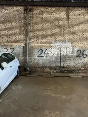 a white car parked in front of a brick wall at Alberdi Urbano in Cordoba