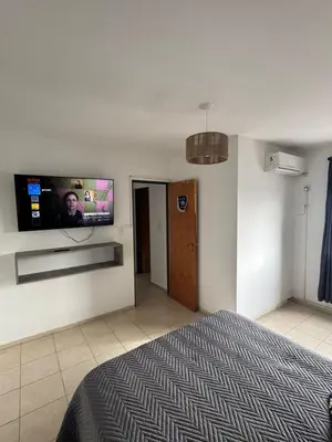 a bedroom with a bed and a flat screen tv on the wall at Alberdi Urbano in Cordoba
