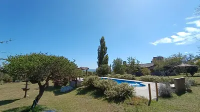 a house with a swimming pool in a yard at Las Acacias Suites in Las Rabonas