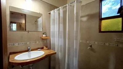 a bathroom with a sink and a shower with a mirror at Las Acacias Suites in Las Rabonas