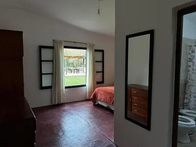 a bedroom with a bed and a mirror and a window at Real del Cóndor San Clemente in San Clemente
