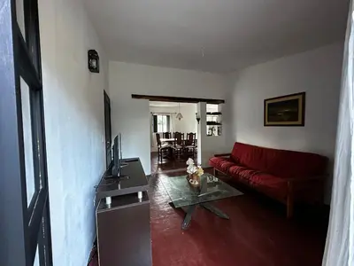 a living room with a red couch and a table at Real del Cóndor San Clemente in San Clemente