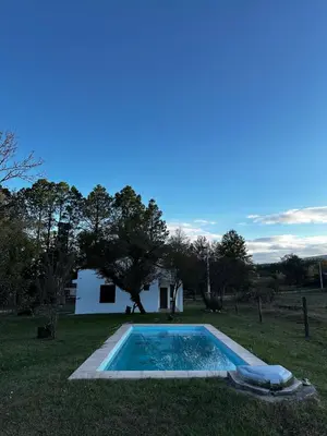 a swimming pool in the grass next to a house at Real del Cóndor San Clemente in San Clemente