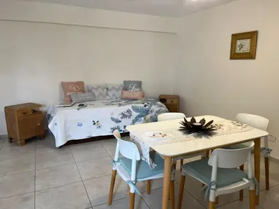 a bedroom with a bed and a table and chairs at Dpto zona Clínica REINA FABIOLA con pileta in Cordoba