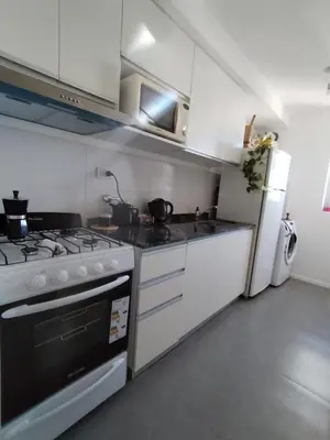 a kitchen with a stove and a refrigerator at Depto 2 dormitorios a estrenar, amplio y luminoso in Cordoba