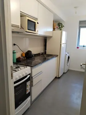 a small kitchen with a stove and a refrigerator at Depto 2 dormitorios a estrenar, amplio y luminoso in Cordoba