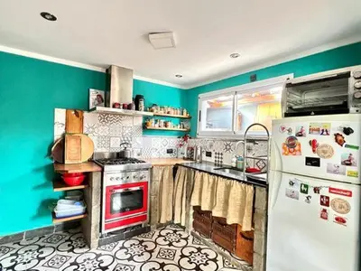 a kitchen with blue walls and a white refrigerator at Casa alojamiento in Cordoba