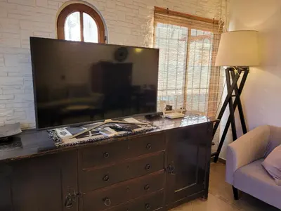 a living room with a large television on a dresser at Crin Blanca in Cordoba