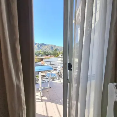 a sliding glass door to a balcony with a table at Tirol D'andrea in Villa General Belgrano