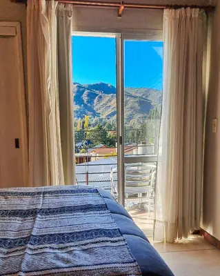 a bedroom with a bed and a view of a mountain at Tirol D'andrea in Villa General Belgrano