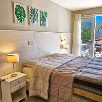 a hotel room with a bed and a window at Tirol D'andrea in Villa General Belgrano