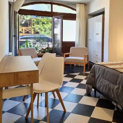 a hotel room with a bed and a table and chairs at Tirol D'andrea in Villa General Belgrano