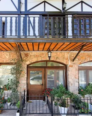 a building with a wooden door and a balcony at Tirol D'andrea in Villa General Belgrano