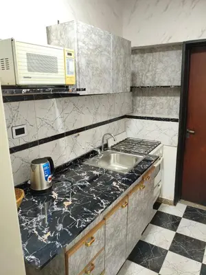 a kitchen with a sink and a microwave at Departamento Barrio General Paz in Cordoba