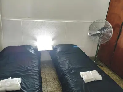 a small room with a bed and a fan at Departamento Barrio General Paz in Cordoba