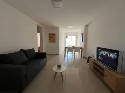 a living room with a black couch and a flat screen tv at Jardines del Boulevard 6 in Cordoba