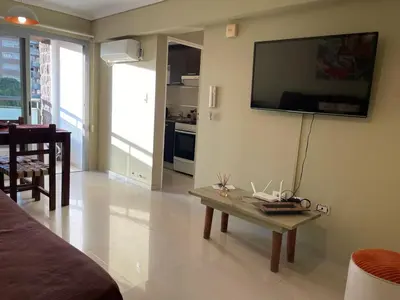 a living room with a table and a tv on the wall at Departamento en Altos de Villa Sol y Seguridad 24h - Córdoba, Argentina in Cordoba