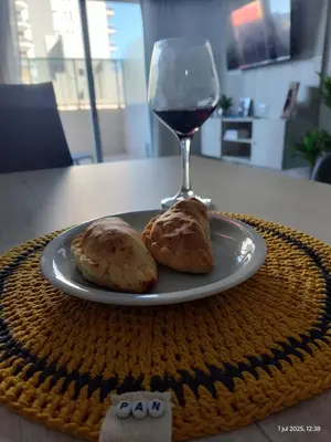 a plate with two pastries and a glass of wine at Espacio PAN in Villa Carlos Paz