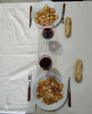 a table with two plates of food and a glass of wine at Espacio PAN in Villa Carlos Paz