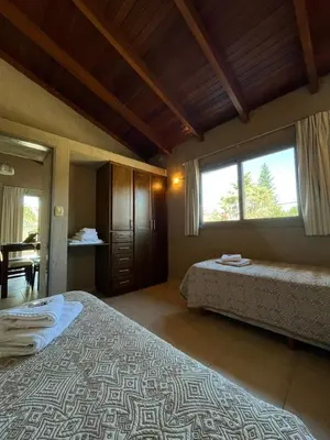 a bedroom with two beds and a large window at Complejo de Cabañas Aires de Santiago in San Antonio de Arredondo