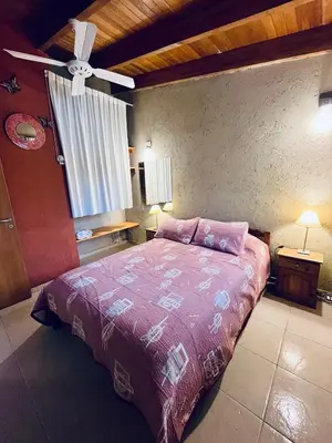 a bedroom with a bed and a ceiling fan at Complejo de Cabañas Aires de Santiago in San Antonio de Arredondo