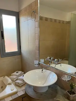 a bathroom with a sink and a tub and a mirror at Complejo de Cabañas Aires de Santiago in San Antonio de Arredondo