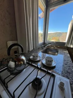 a kitchen stove with a tea kettle and cups on it at Complejo de Cabañas Aires de Santiago in San Antonio de Arredondo