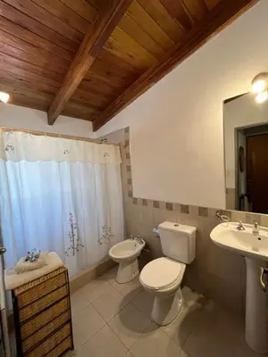 a bathroom with two toilets and a sink and a mirror at Complejo de Cabañas Aires de Santiago in San Antonio de Arredondo