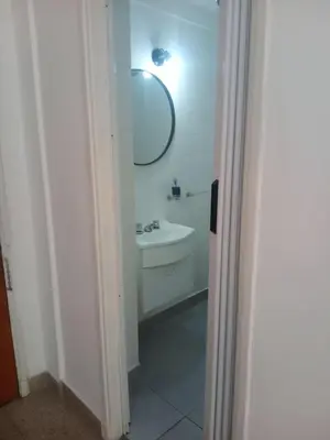 a white bathroom with a sink and a mirror at Monoambiente Centro villa Carlos Paz in Villa Carlos Paz