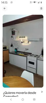 a kitchen with a stove and a sink and a table at Monoambiente Centro villa Carlos Paz in Villa Carlos Paz