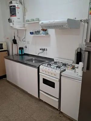 a kitchen with a white stove and a sink at Monoambiente Centro villa Carlos Paz in Villa Carlos Paz