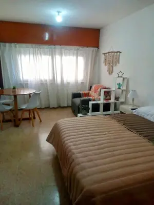 a bedroom with a bed and a couch and a table at Monoambiente Centro villa Carlos Paz in Villa Carlos Paz