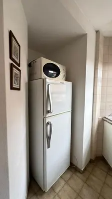 a microwave sitting on top of a refrigerator in a kitchen at Ayacucho loft in Cordoba
