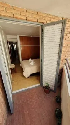 a view of a bedroom with a bed through a sliding glass door at Ayacucho loft in Cordoba