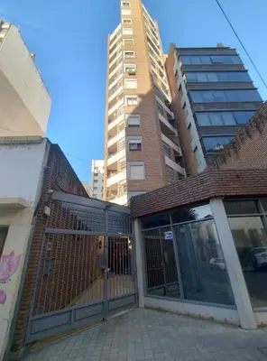 a building with a gate in front of some tall buildings at Ayacucho loft in Cordoba