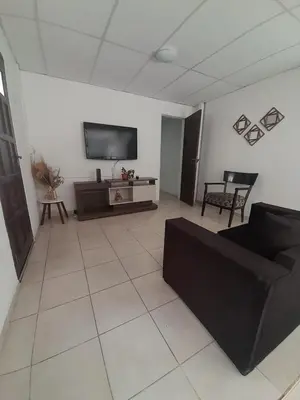 a living room with a black couch and a tv at Departamento La Cuesta in Villa Carlos Paz