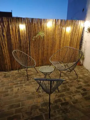 two chairs and a table in front of a wooden wall at Departamento La Cuesta in Villa Carlos Paz