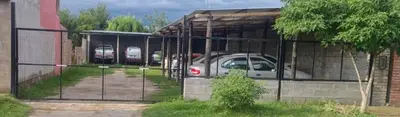 a fence with a car parked in a garage at Hospedaje Pringles in Santa Rosa del Conlara