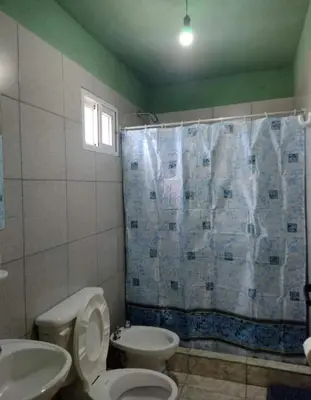 a bathroom with a toilet and a sink and a shower at Hospedaje Pringles in Santa Rosa del Conlara