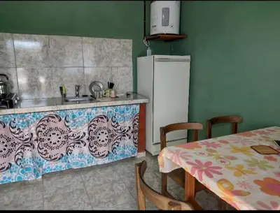 a kitchen with a sink and a table and a refrigerator at Hospedaje Pringles in Santa Rosa del Conlara