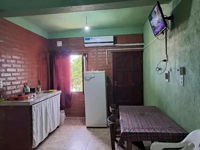 a kitchen with a refrigerator and a table in it at Hospedaje Pringles in Santa Rosa del Conlara